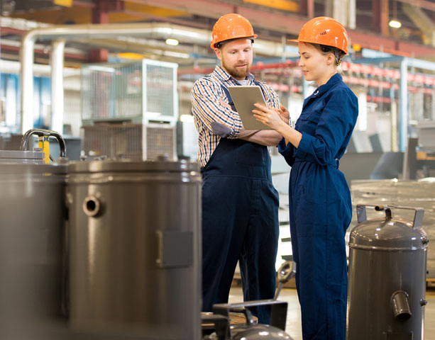 Two people in conversation with hard hats